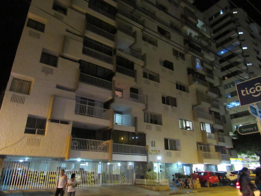 un edificio alto con gente parada frente a él en Apartamento en El Rodadero - El Morro, en Santa Marta