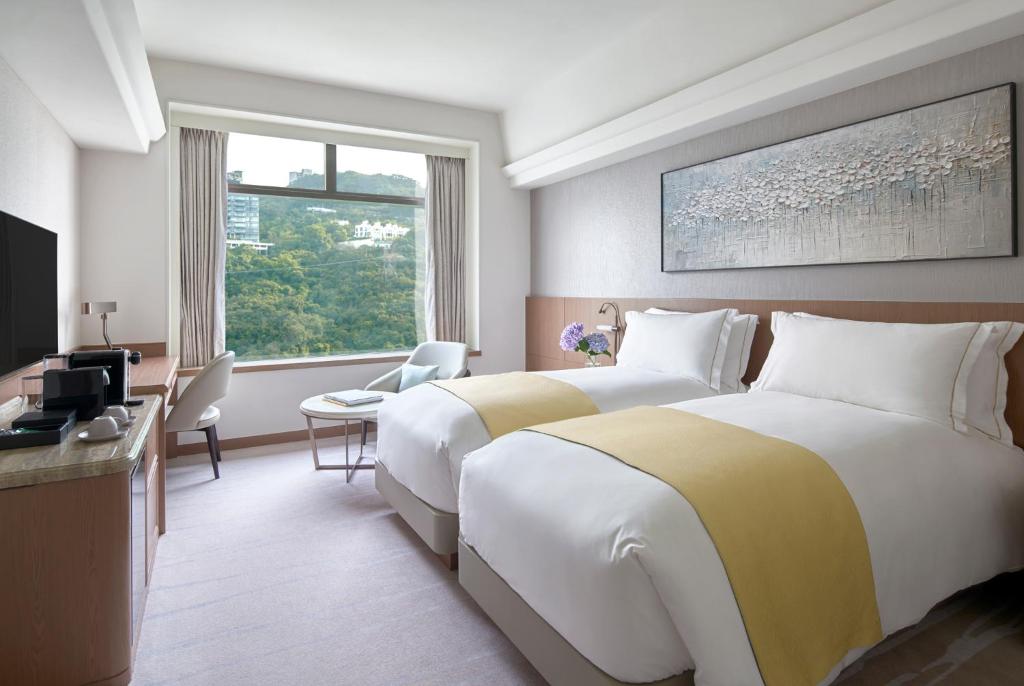 una camera d'albergo con due letti e una finestra di Hopewell Hotel a Hong Kong
