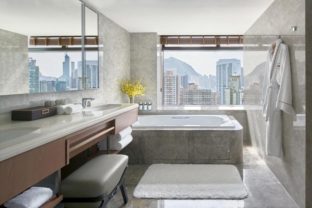 bagno con vasca, lavandino e finestra di Hopewell Hotel a Hong Kong