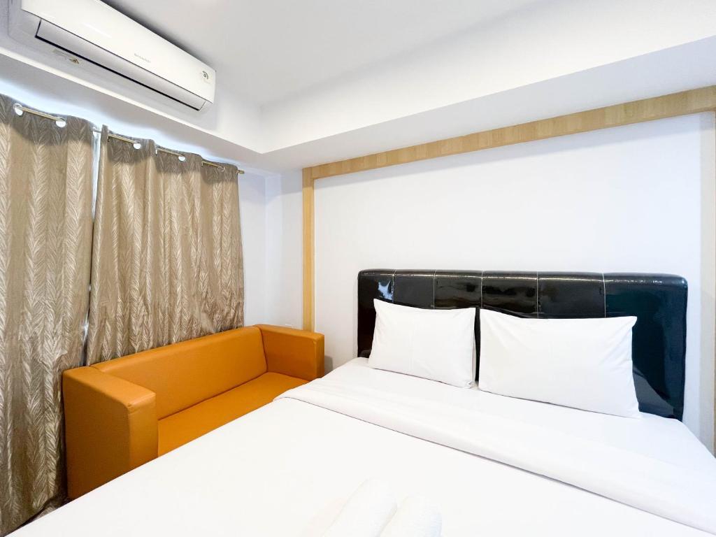 メダンにあるModern Look Studio at De Prima Apartment By Travelioのベッドルーム1室(ベッド1台、黄色のヘッドボード付)