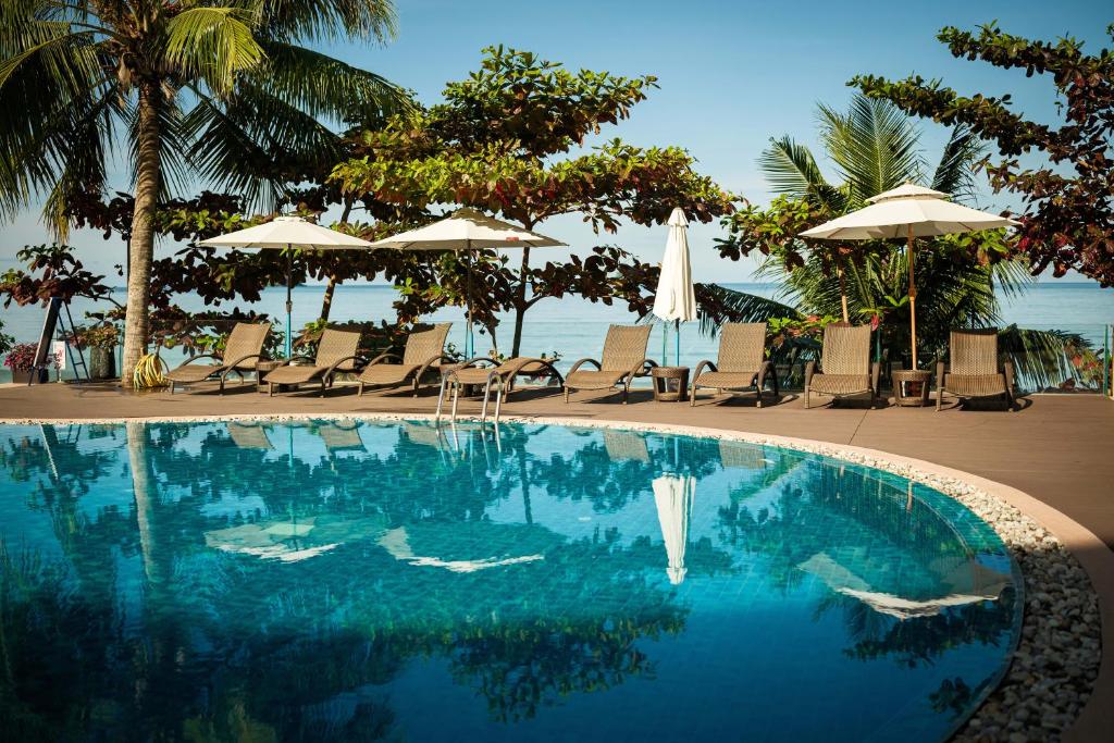 a swimming pool at a resort with chairs and umbrellas at KaiBaeBeach GrandView in Ko Chang