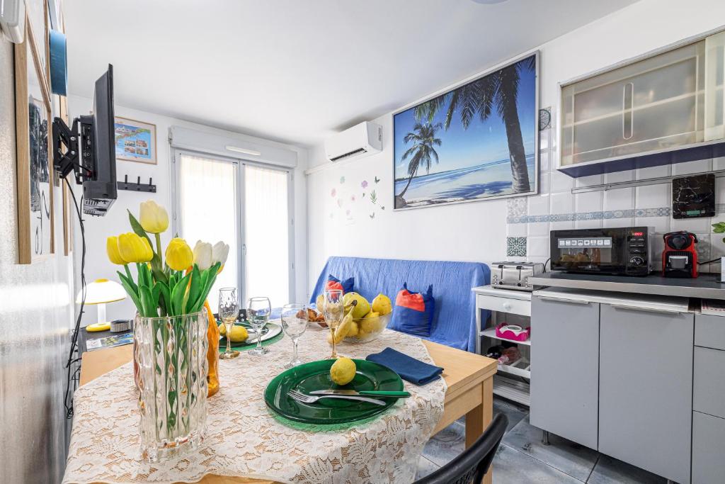 une cuisine avec une table avec un vase de fleurs dessus dans l'établissement Apartement La Fenice - Happy Rentals, à Nice