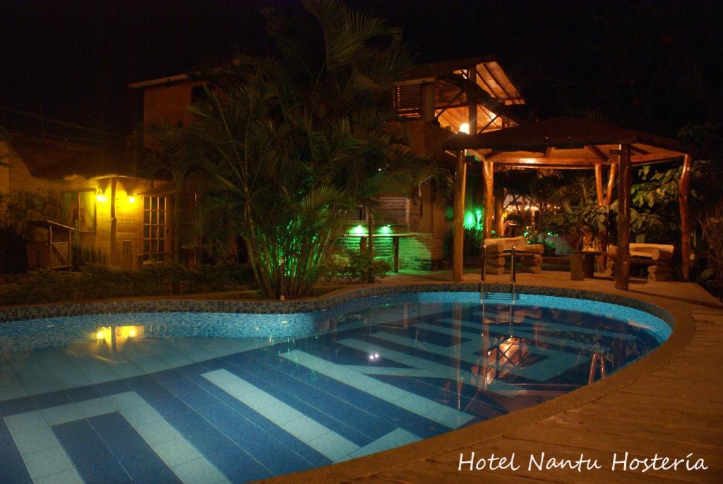 a swimming pool in a yard at night at Hotel Nantu Hostería in Puerto López