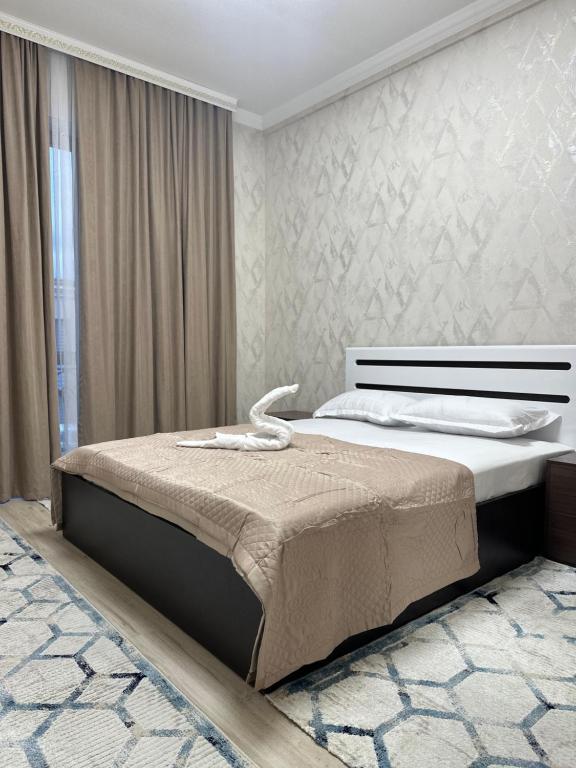 a bedroom with a large bed in a room at Жк Керуен Сарай Vip in Türkistan