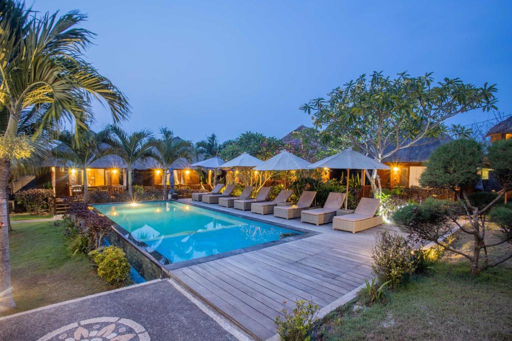 a villa with a swimming pool and a resort at Lembongan Mantra Huts in Nusa Lembongan
