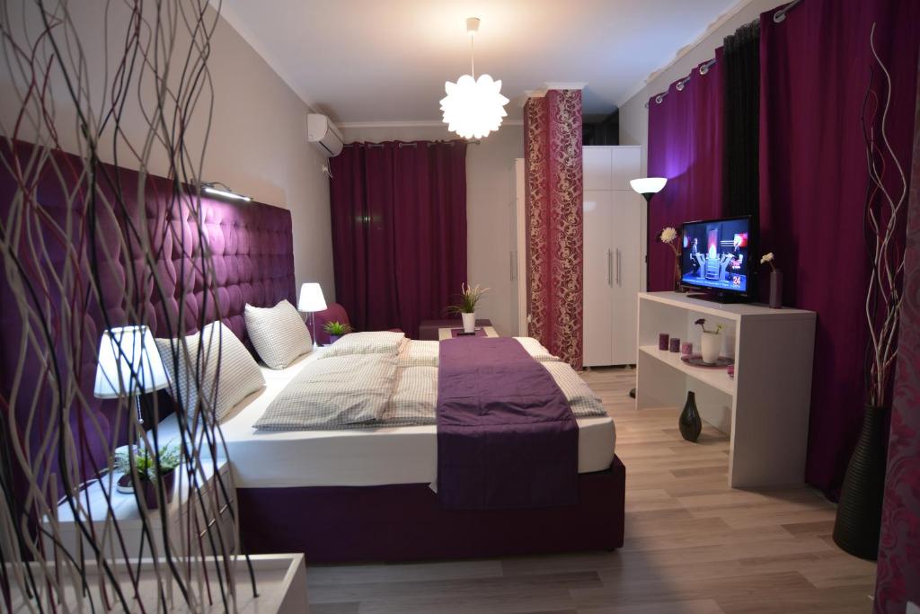 a bedroom with a large bed and purple curtains at Villa Radica in Negotino