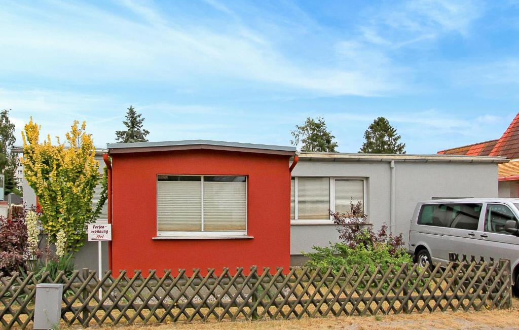 une maison rouge avec une camionnette garée devant elle dans l'établissement Ferienhaus Zinnowitz Seebad, à Zinnowitz