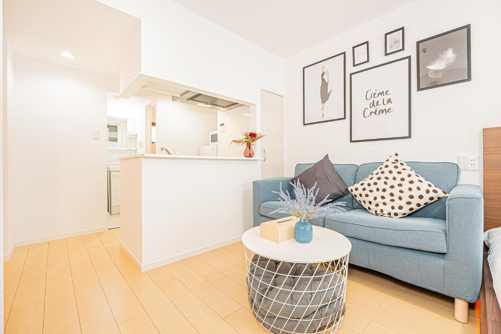 a living room with a blue couch and a table at New-built APT at Asakusa-Skytree area with Tranquil block in Tokyo