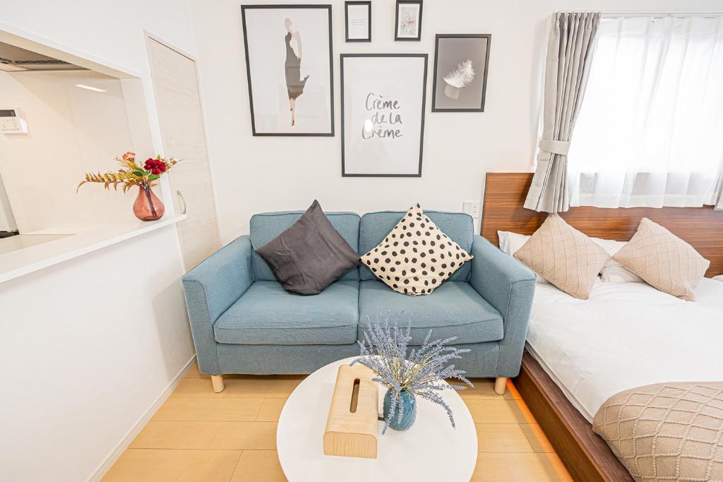 a living room with a blue couch and a bed at New-built APT at Asakusa-Skytree area with Tranquil block in Tokyo