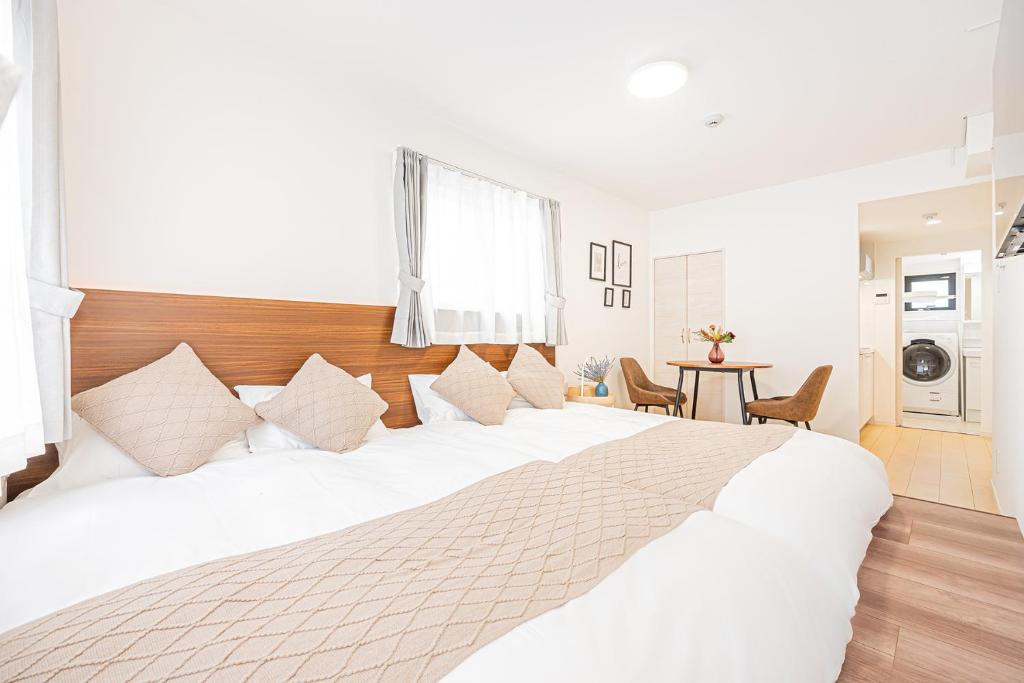 a large white bed in a room with a table at New-built APT at Asakusa-Skytree area with Tranquil block in Tokyo
