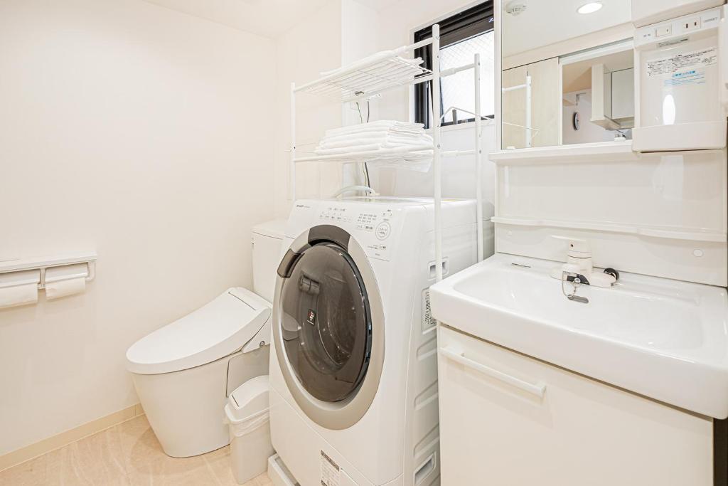 a white laundry room with a washing machine and a sink at New-built APT at Asakusa-Skytree area with Tranquil block in Tokyo