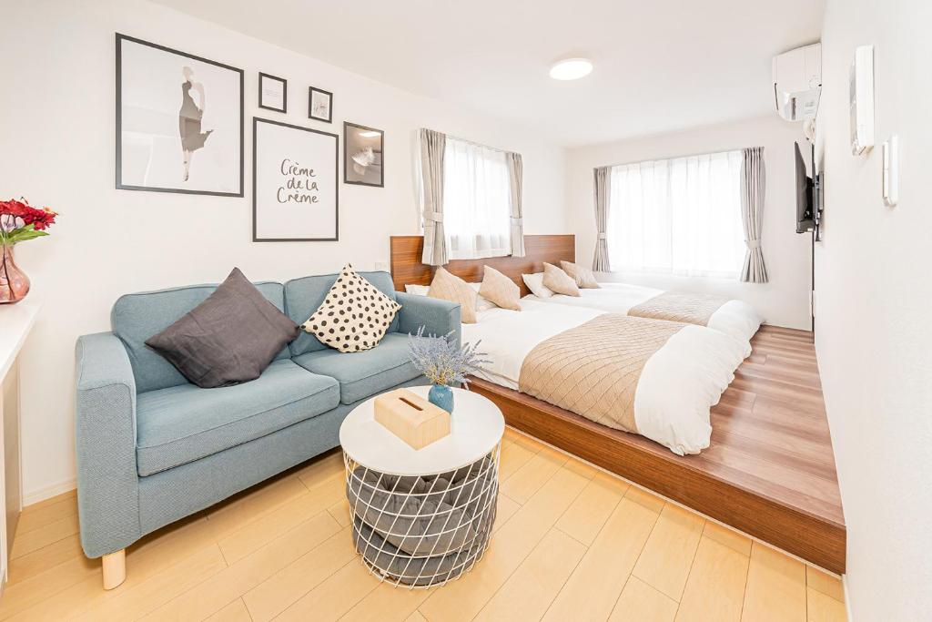 a living room with a bed and a blue couch at New-built APT at Asakusa-Skytree area with Tranquil block in Tokyo