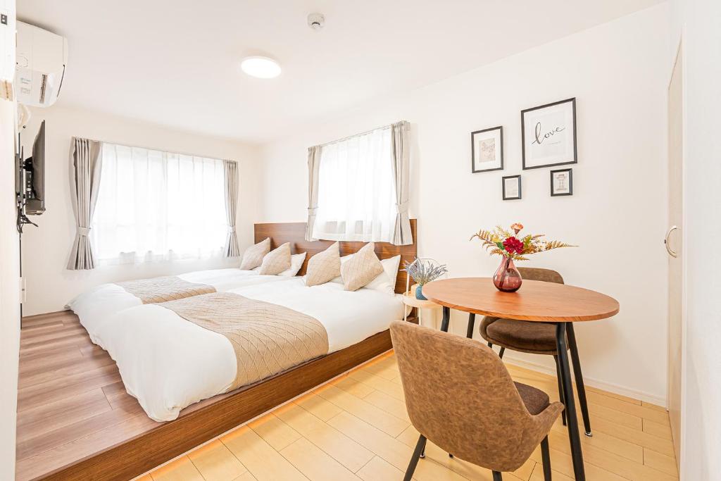 a white bedroom with a bed and a table at New-built APT at Asakusa-Skytree area with Tranquil block in Tokyo