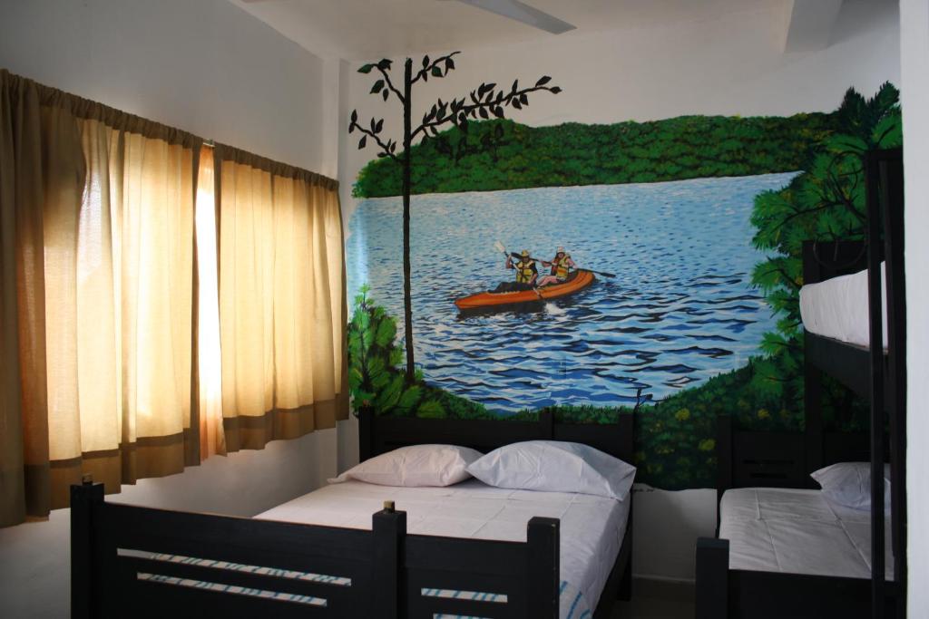 un dormitorio con una pintura de dos personas en una canoa en Hotel Calle8 en Tuxtla Gutiérrez