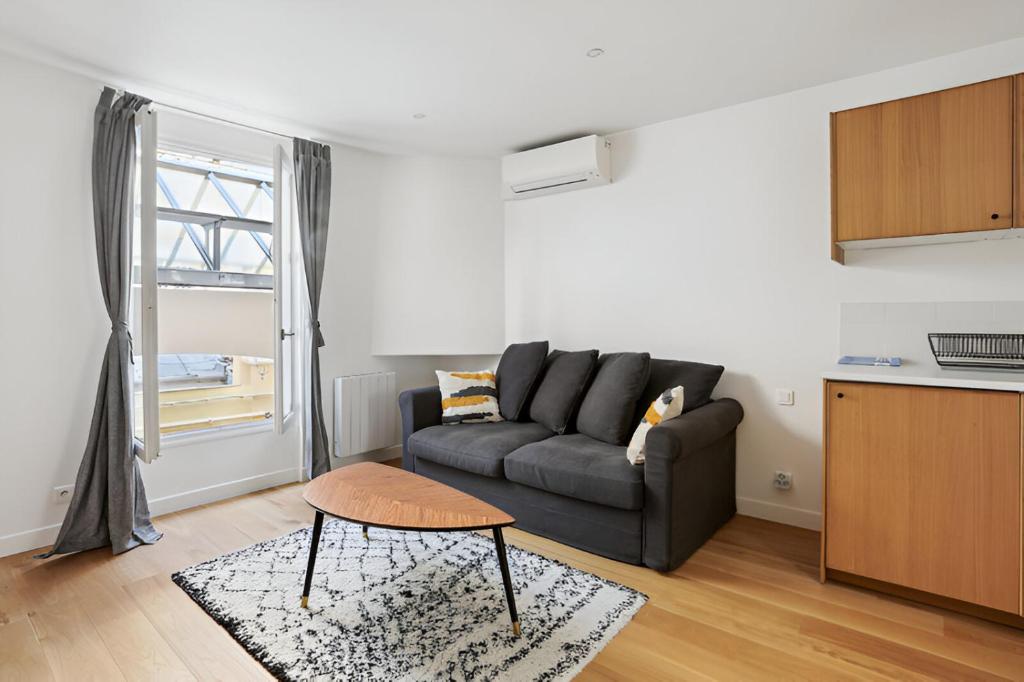 un salon avec un canapé et une table dans l'établissement 333 Suite Chou - Superbe Appartement à Paris., à Paris