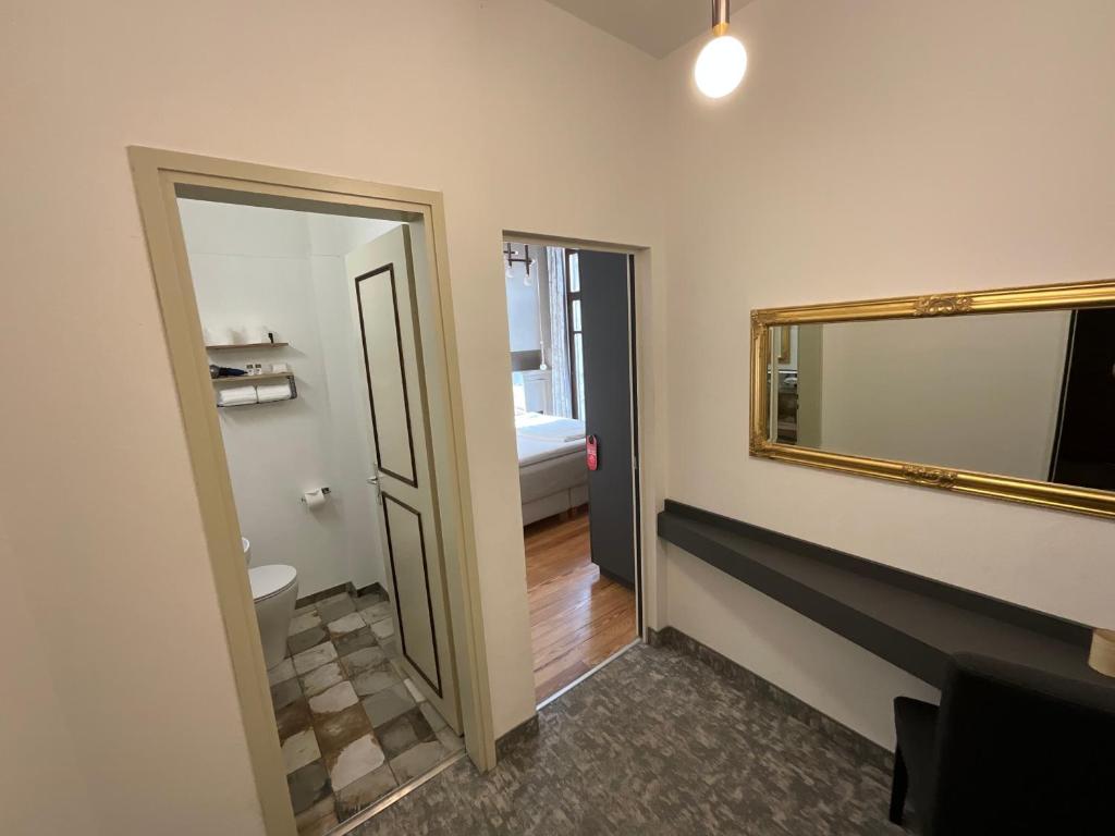 un bagno con un grande specchio e un corridoio di Arbostora Charme Hotel a Morcote