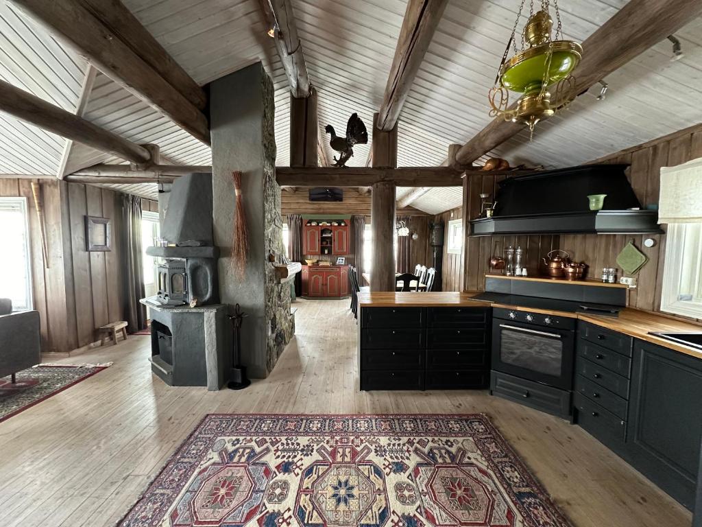 a kitchen with a stove and a rug on the floor at Welcoming Cabin with Fireplace & Modern Kitchen in Beitostøl