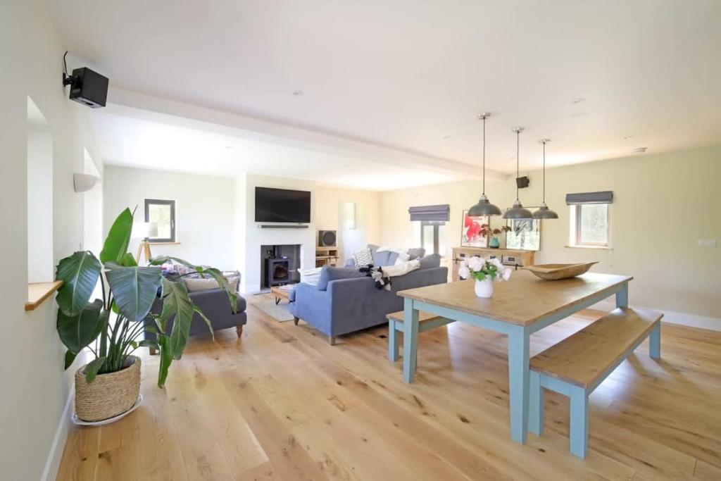 a living room with a table and a blue couch at Contemporary Cottage & Garden in Dorset in Blandford Forum