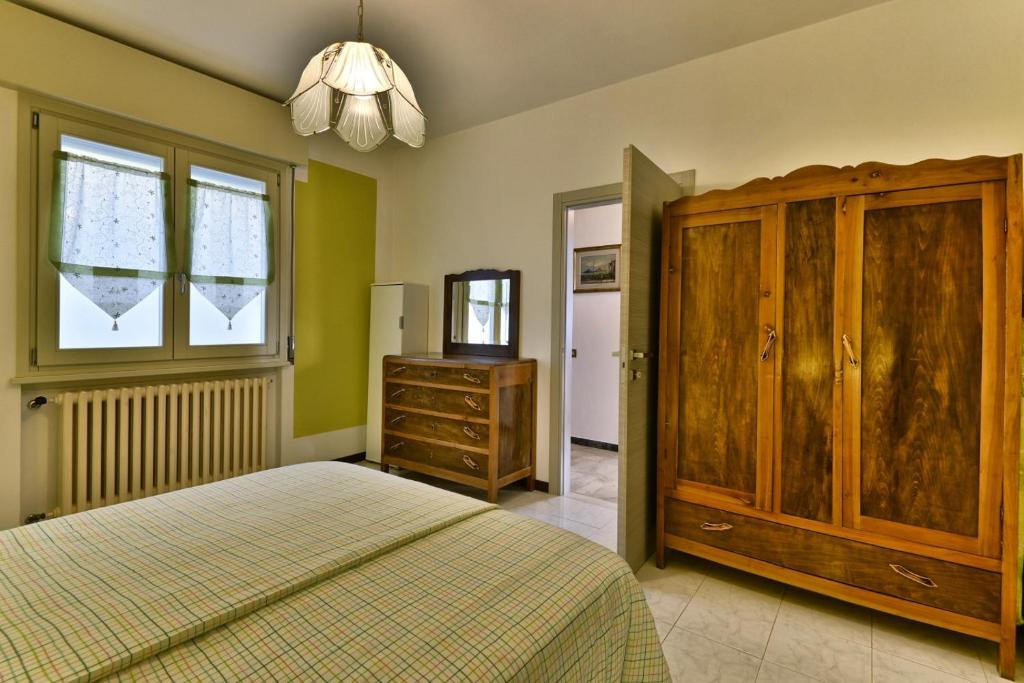 sypialnia z łóżkiem, komodą i oknem w obiekcie Villa Margherita - Theater Home w mieście Tignale