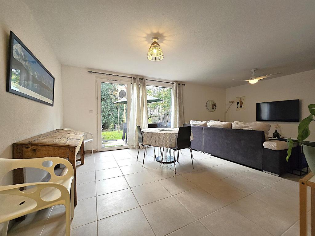 un salon avec un lit et une table dans l'établissement Charmante maison 6 personnes - 5 min à pied zone commerciale Sapiac - 3 chambres - 4 lits - Jardin et terrasses privés - Parking gratuit sur place, à Montauban