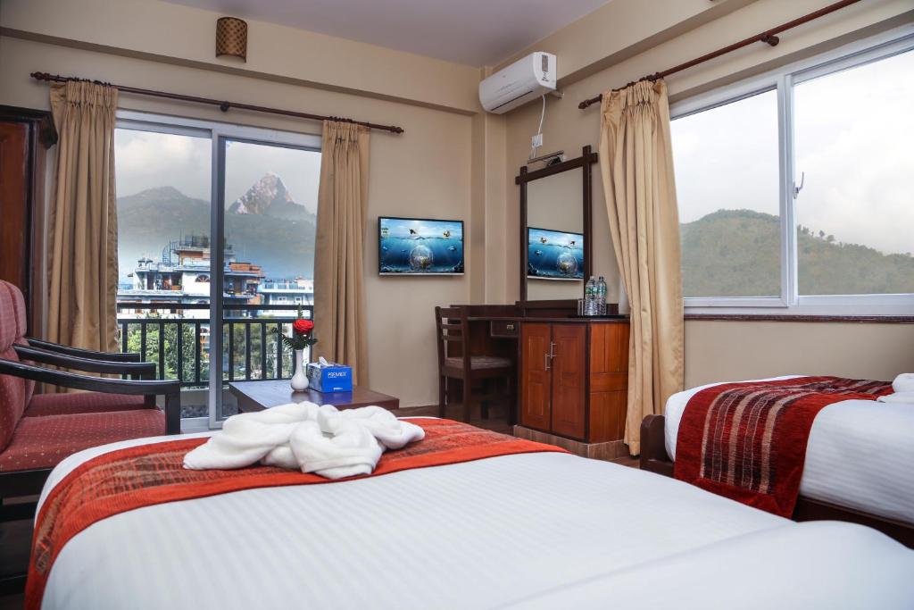 Postel nebo postele na pokoji v ubytování Pokhara Choice Inn