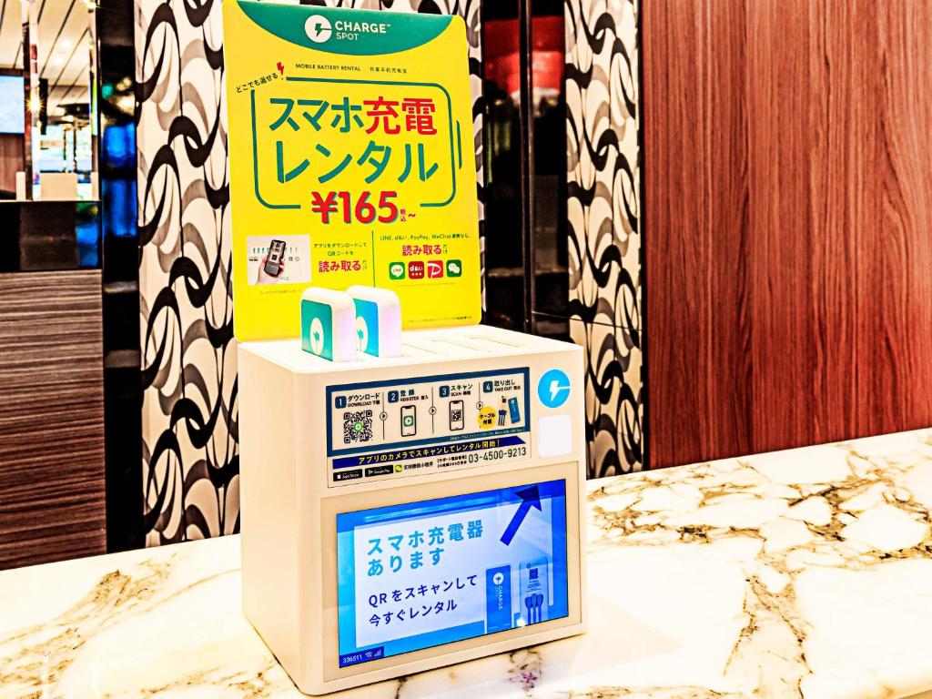 a sign on top of a machine on a counter at APA Hotel Ningyocho Ekikita in Tokyo