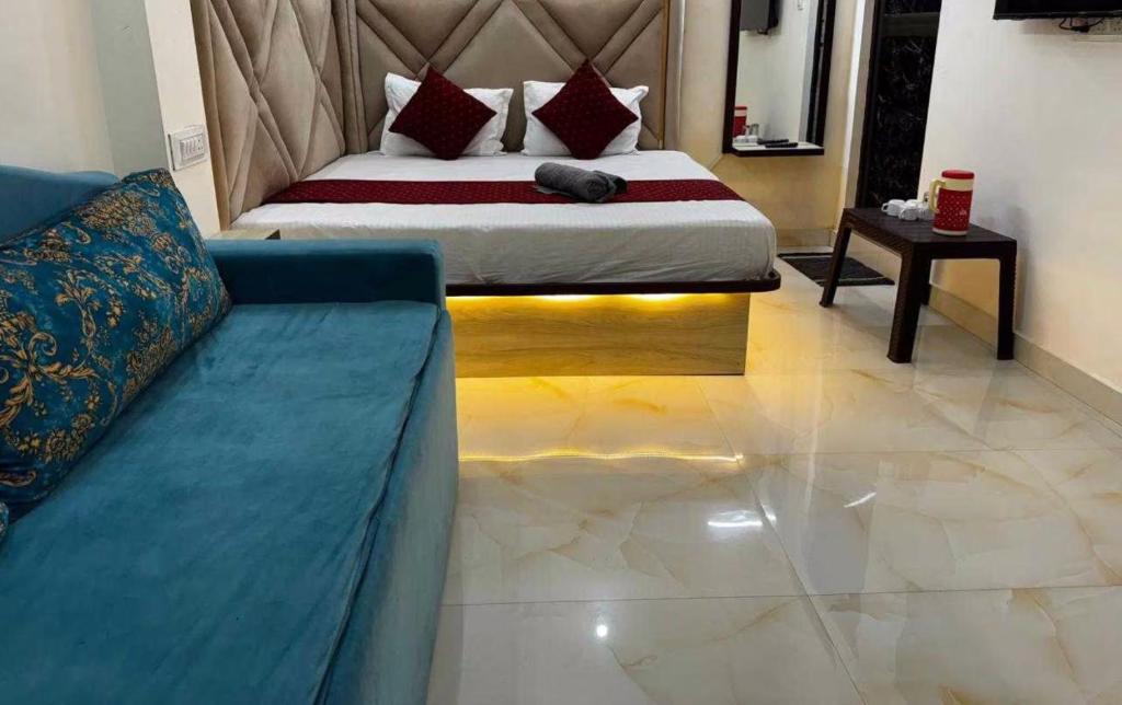 a bedroom with a bed and a couch in a room at Super Hotel O City Inn in Ayodhya