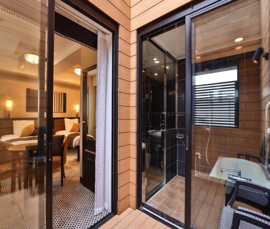 a bathroom with a glass door leading to a bedroom at APA Hotel Ningyocho Ekikita in Tokyo