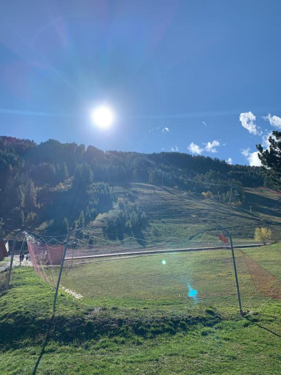 - une vue sur un champ avec le soleil dans le ciel dans l'établissement Appartement au pied des pistes, à Uvernet