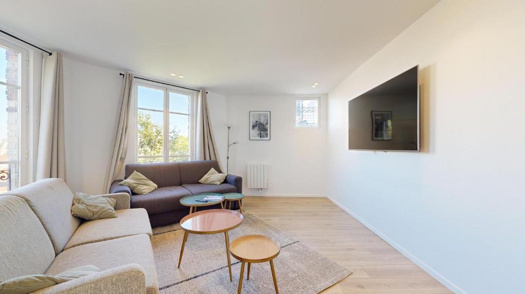 un salon avec un canapé et deux tables dans l'établissement 157 Suite Sacha - Superbe Duplex à Paris, à Paris
