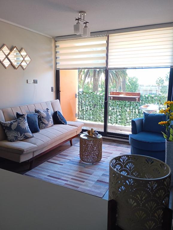 a living room with a couch and a large window at Disfruta de Valparaiso in Valparaíso