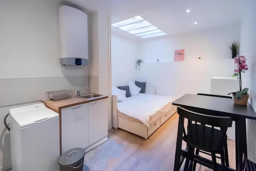 une chambre avec un lit et une cuisine avec une table dans l'établissement YSER, à Rouen