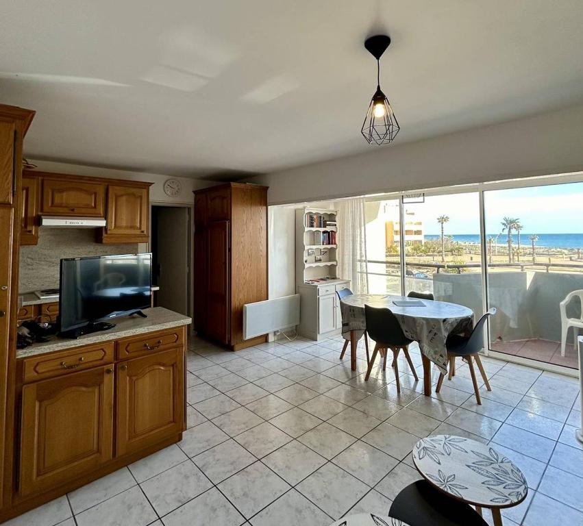 une cuisine avec une table et une vue sur l'océan dans l'établissement Charmant T2 à deux pas de la plage 4SL132, au Barcarès