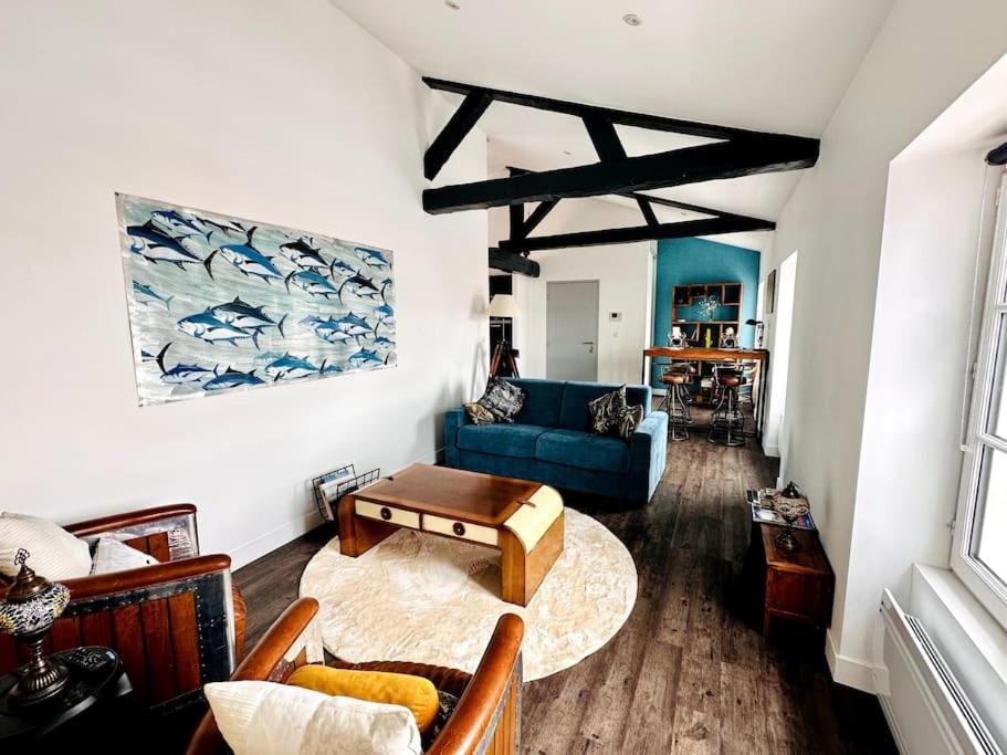 un salon avec un canapé bleu et une table dans l'établissement Le Gambetta - Marché Central, à La Rochelle