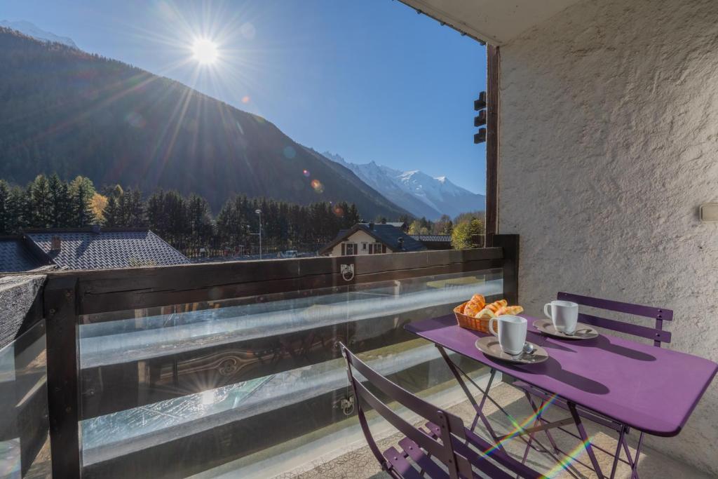 d'une table et de chaises violettes sur un balcon avec vue. dans l'établissement Hautes Aiguilles 21 - Happy Rentals, à Chamonix-Mont-Blanc