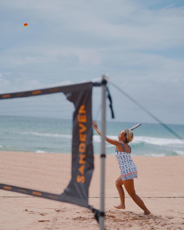 a woman is playing volleyball on the beach at Nyne Hotels Rock Villa, Bentota in Bentota