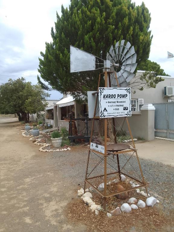 a windmill and a sign in front of a house at Karoo Pomp in Vosburg