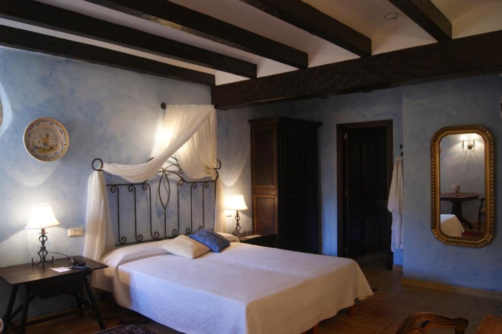 a bedroom with a white bed and a mirror at Hostal La Panavera in Perelló