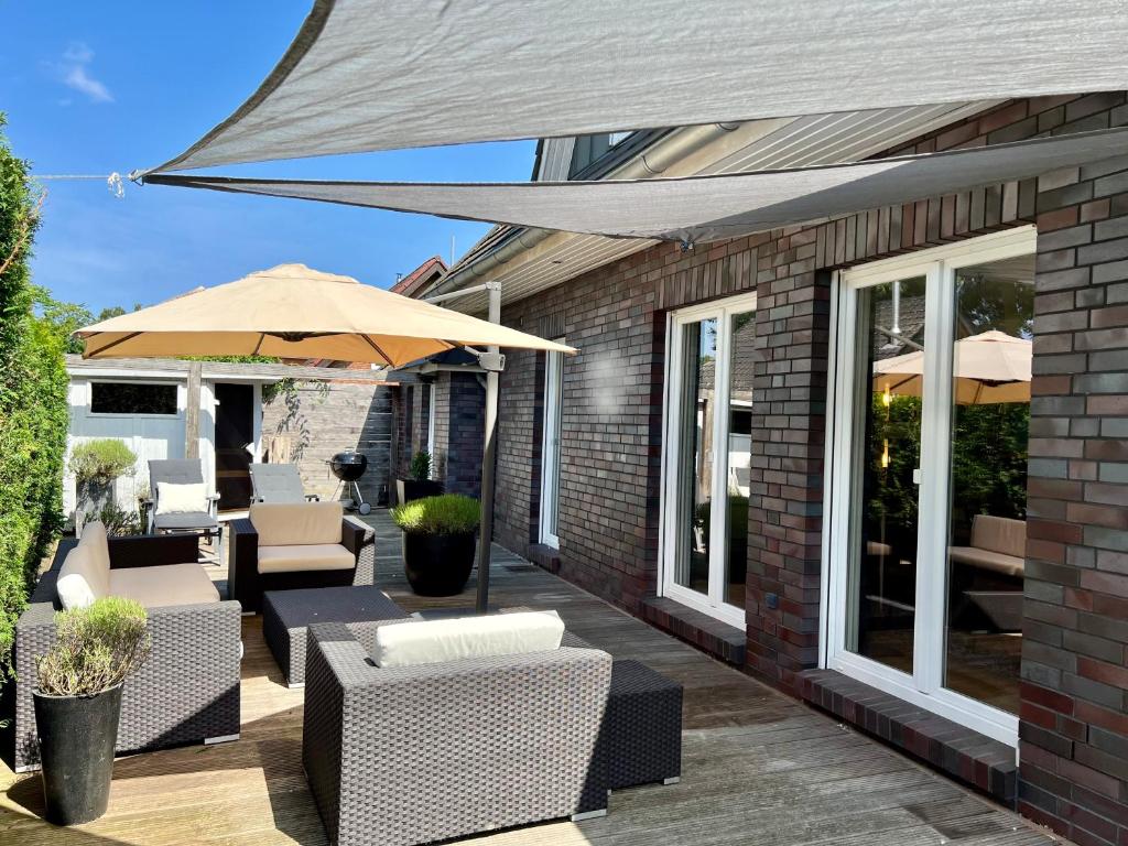 a patio with tables and chairs and an umbrella at Ferienhaus Celeste in Warnemünde