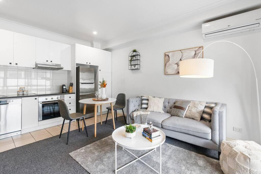 una sala de estar con un sofá y una mesa en The Cornerstone on Inkerman, en Melbourne