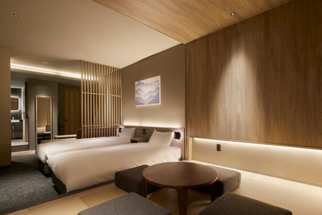 pokój hotelowy z dwoma łóżkami i stołem w obiekcie Minn Asakusa Kuramae Station w Tokio