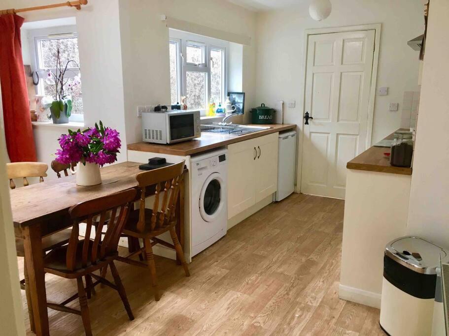 eine Küche mit einem Tisch und einer Waschmaschine in der Unterkunft HOLIDAY HOUSE TANYGRISIAU SNOWDONIA North Wales in Tanygrisiau