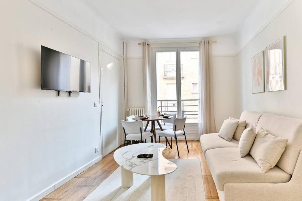 un salon blanc avec un canapé et une table dans l'établissement Évasion parisienne Monceau & Arc de Triomphe - II, à Neuilly-sur-Seine