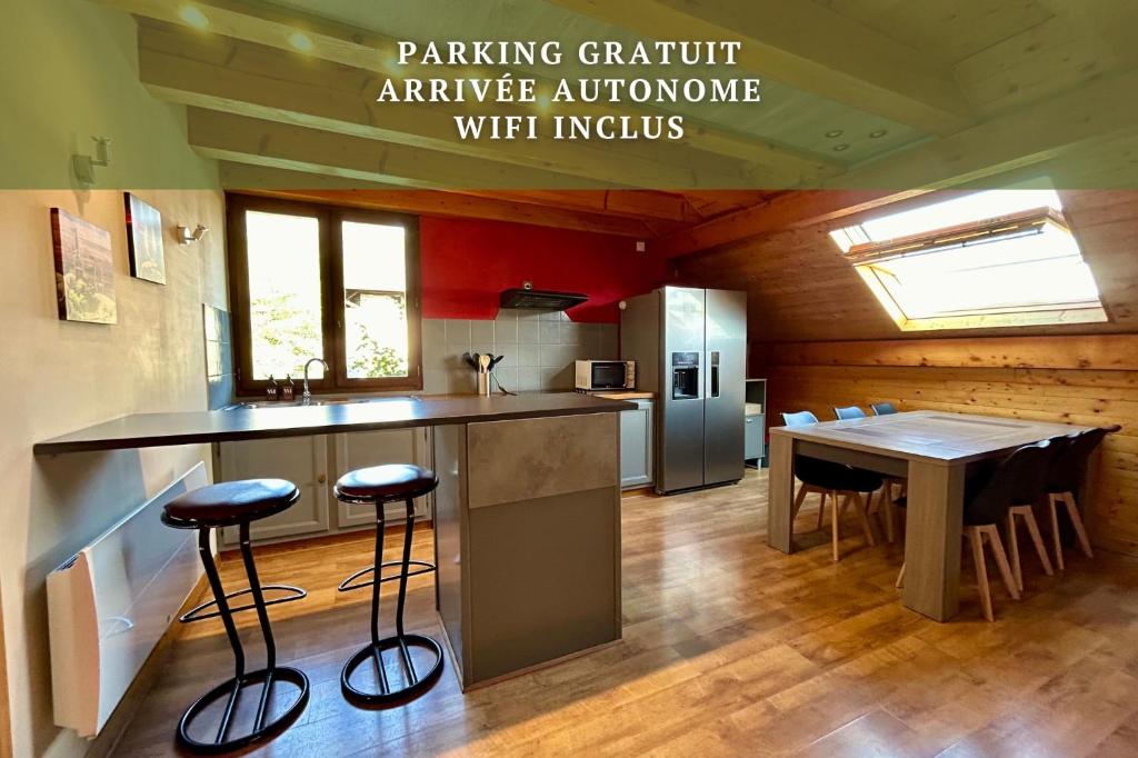 une cuisine avec un comptoir et une table avec des tabourets dans l'établissement Chez Fred 201 - Parking Wifi - CLG Savoie, à Chevillard