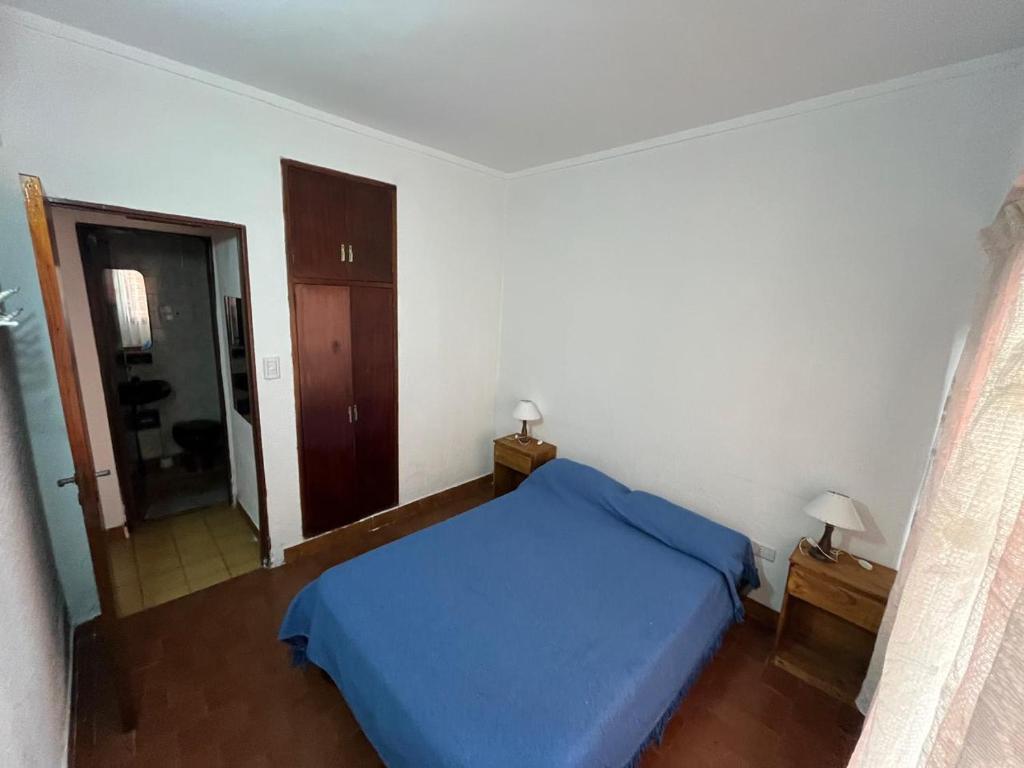 a bedroom with a blue bed and a mirror at El Dorado Deptos a una cuadra del mar in San Bernardo