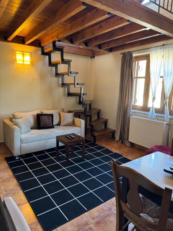 a living room with a white couch and a staircase at Frigias 1 in Arachova