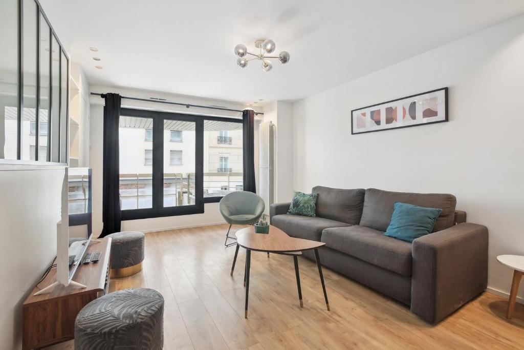 un salon avec un canapé et une table dans l'établissement Bluestay 46 - Superbe appartement à Paris, à Paris