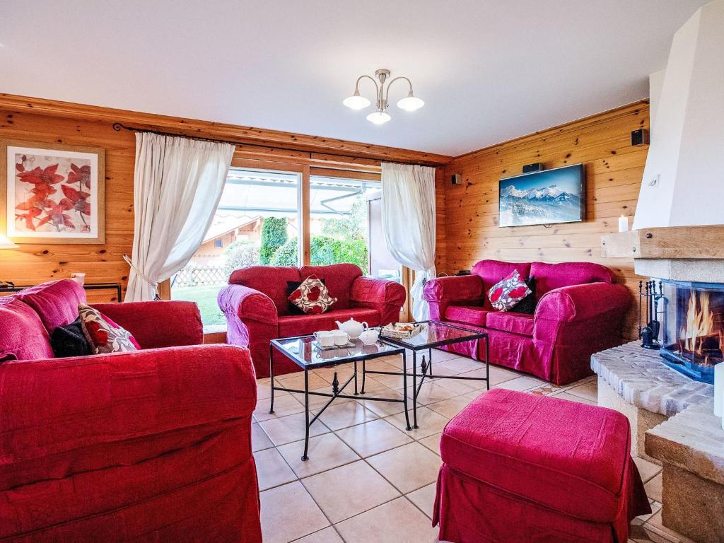 ein Wohnzimmer mit roten Sofas und einem Kamin in der Unterkunft Apartment Ambre-6 by Interhome in Villars-sur-Ollon