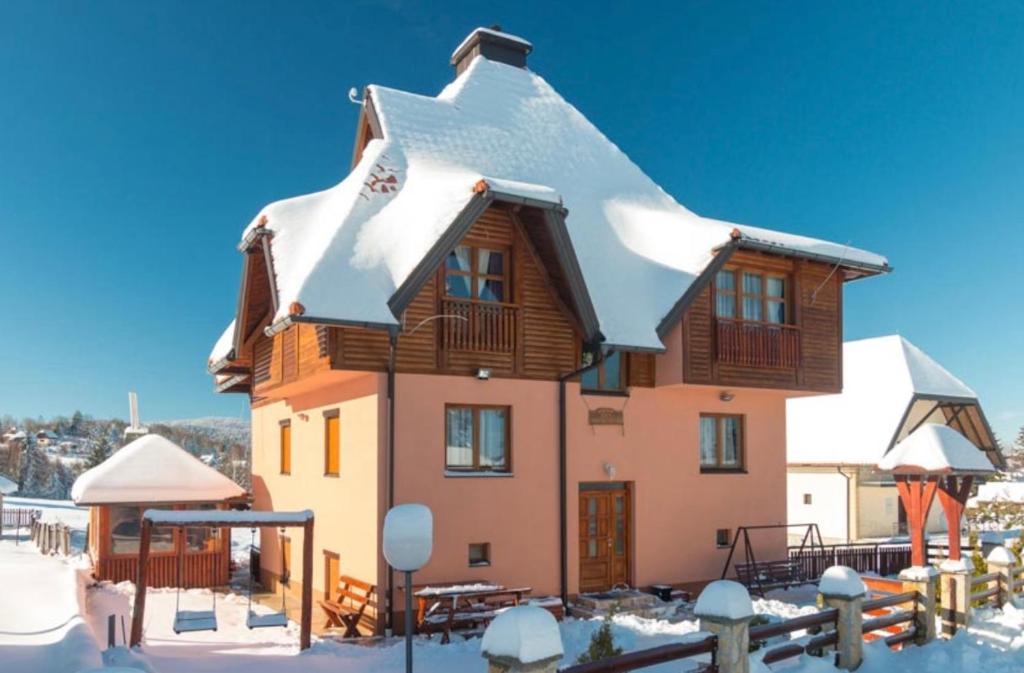 a house with snow on top of it at Vila Zlatna Pahulja in Bajina Bašta