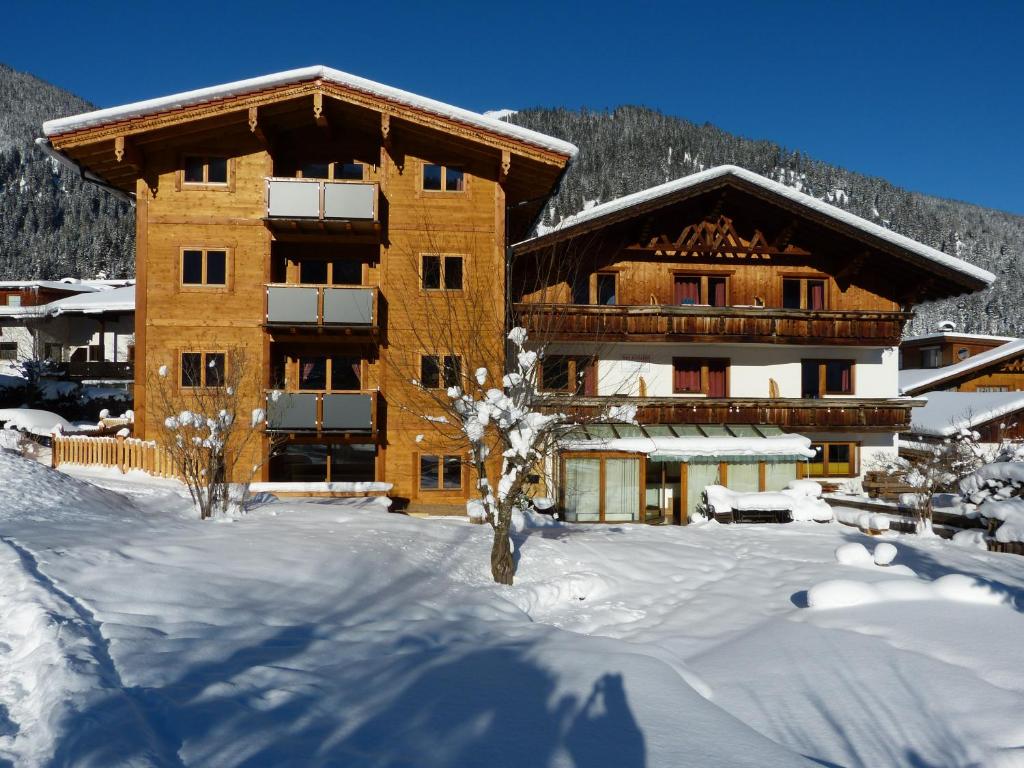 a large building with snow in front of it at Appartements Alpenland in Lermoos